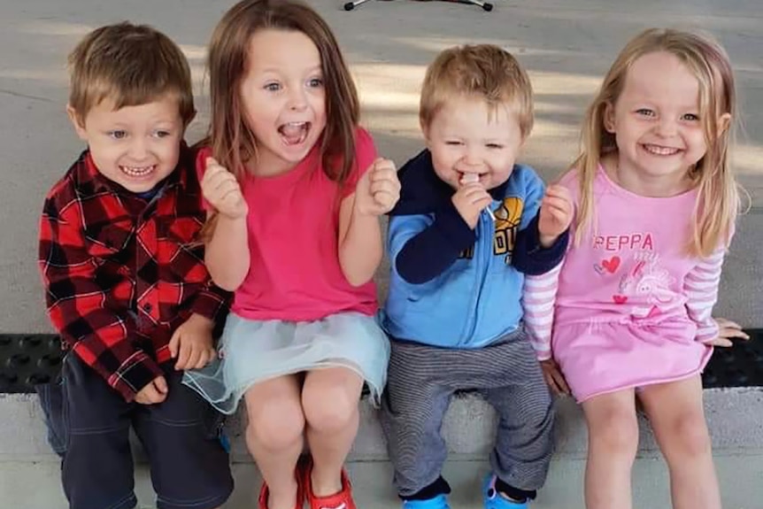 Four young children smiling and laughing