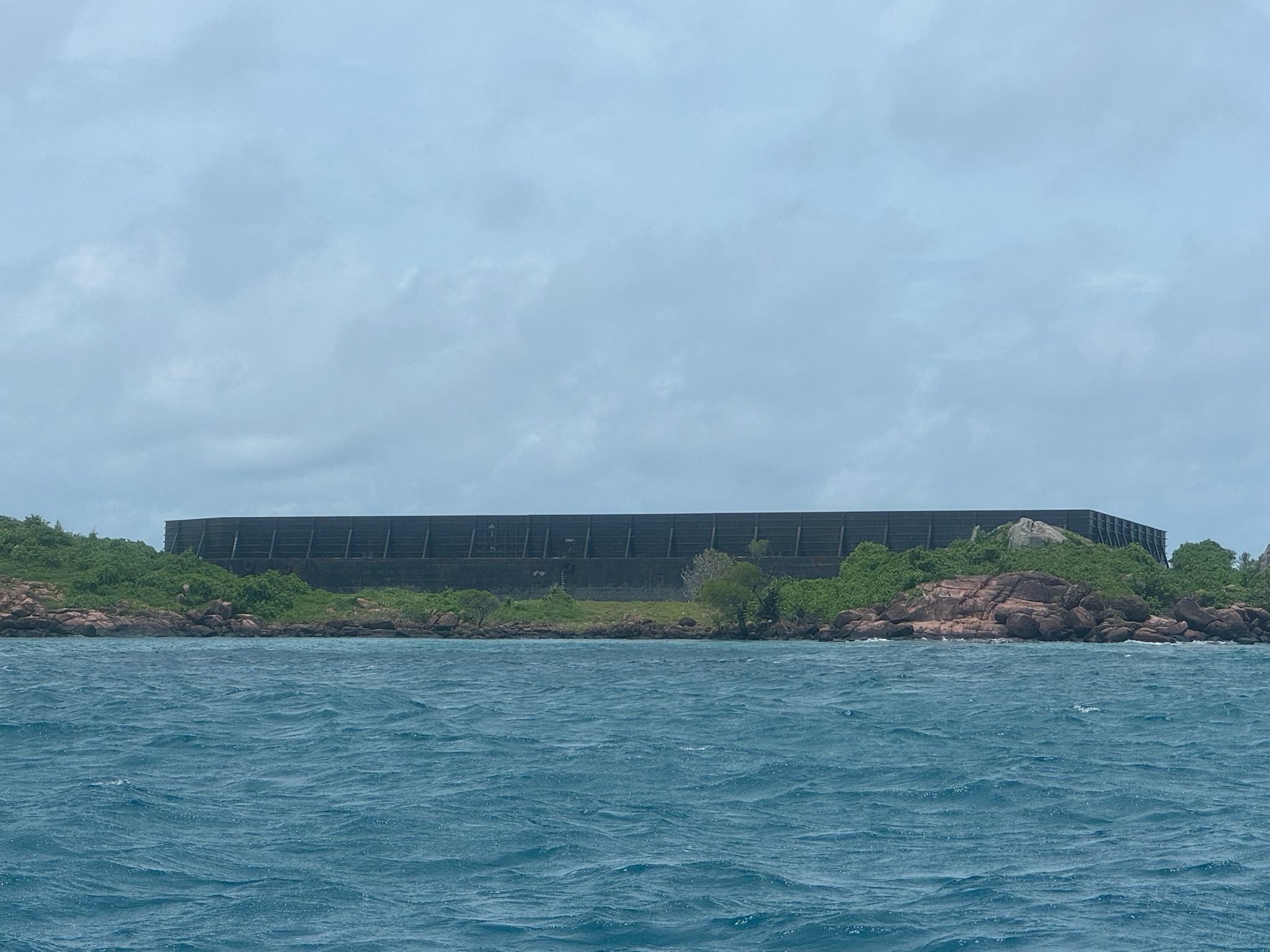 Grande navio preso em uma pequena ilha com água do mar em primeiro plano 