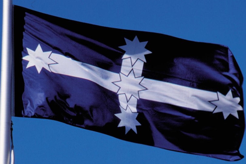 a royal blue flag with a white cross and the stars of the southern cross