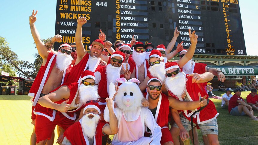 Spectators dressed as Santa Claus watch during Australia - India Test match at Adelaide Oval.