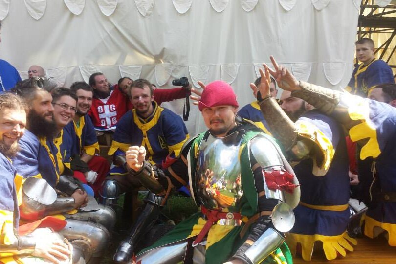 Man in armour celebrates with friends