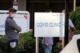 A man stands outside a COVID fever clinic.