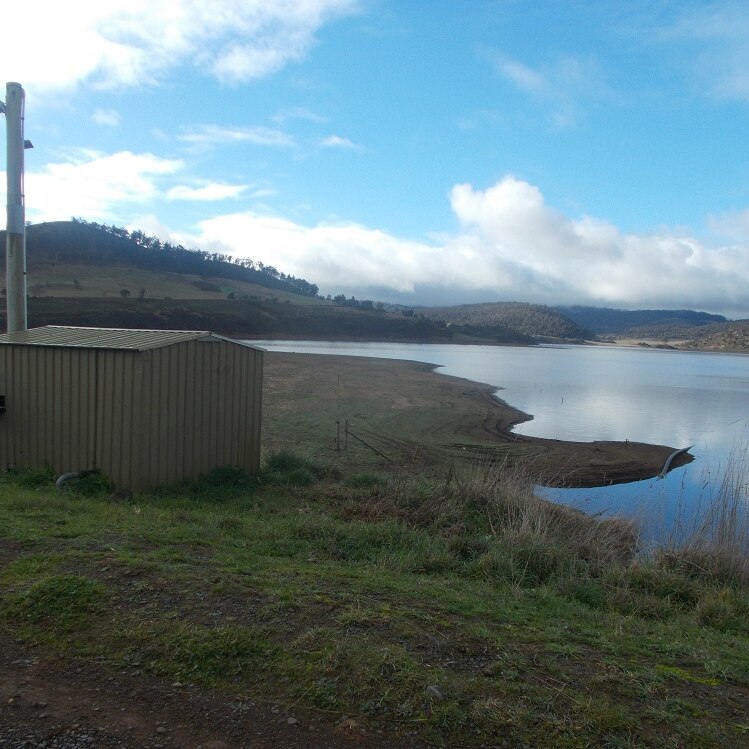 A major dam in Tasmania's south showing low water levels