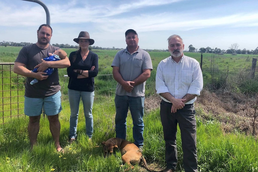 Four Gillieston residents stand in a green paddock near the proposed abattoir site.