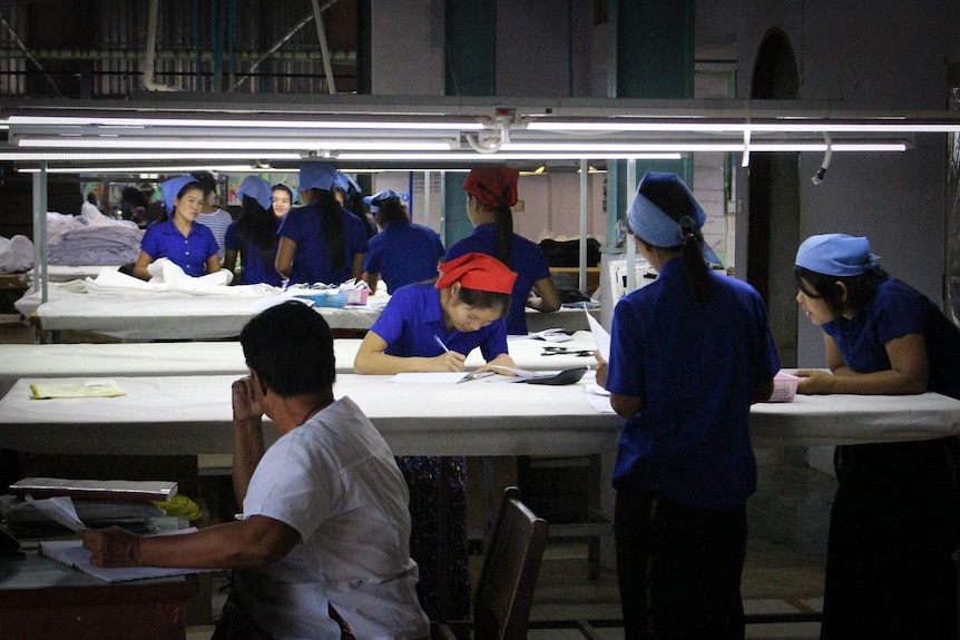 Women measure fabric against patterns