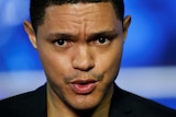 Close up image of Trevor Noah speaking with a frown on his face