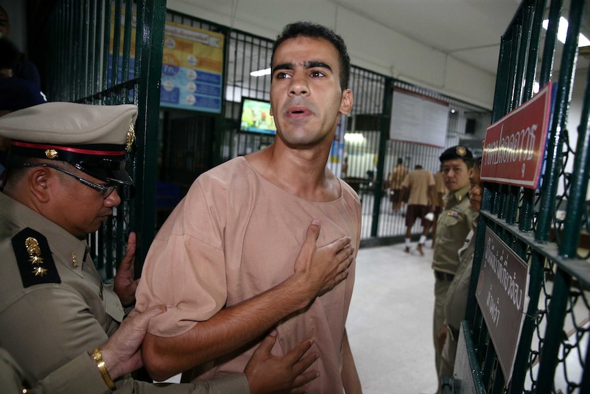 Hakeem al-Araibi gestures to his supporters outside of court in Bangkok.