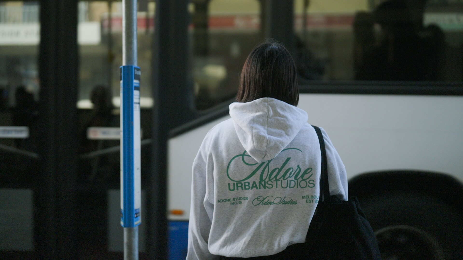 A woman at a bus stop.