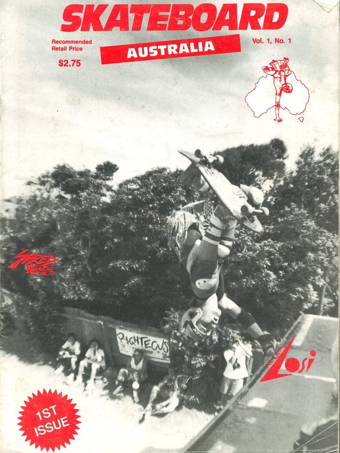 A black and white magazine photo of a skateboarder doing a handstand on the top of a skate ramp