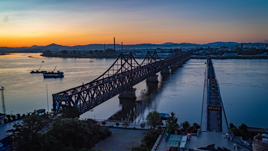 A view of the river and bridge in the Chinese port city of Dandong at sunset.