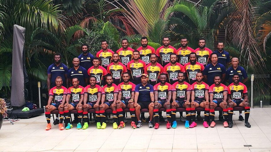 A formal ranked shot of the entire PNG Hunters Rugby League team in their black, red and yellow jerseys.