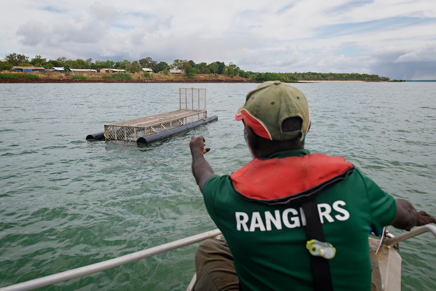 Greg WIlson points out a crocodile trap while on a boat in Maningrida.