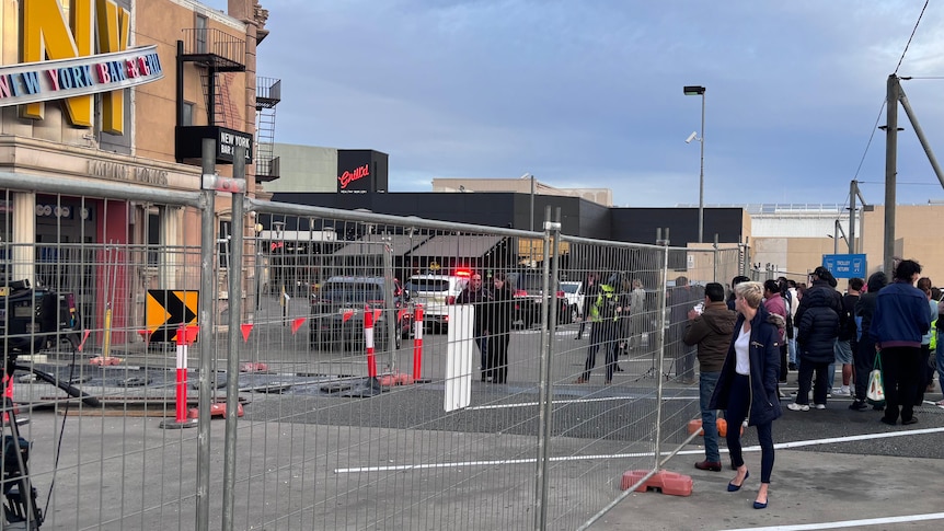 A fence erected to keep bystanders out of a shopping mall at a car park