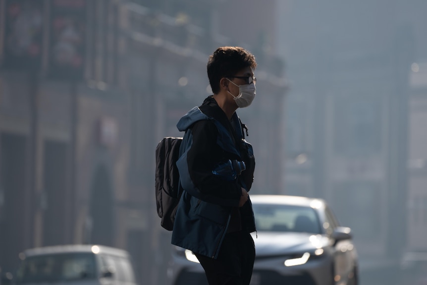 A man wears a mask while walking through Sydney's CBD