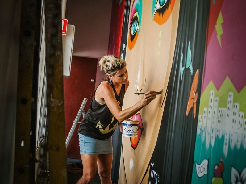 Woman painting a mural