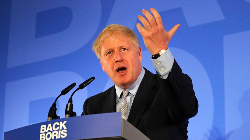 Boris Johnson at a pulpit with open mouth and raised hands.