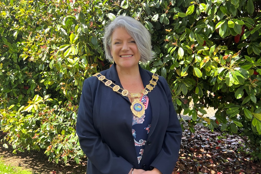 Woman smiles at camera in mayoral robes.