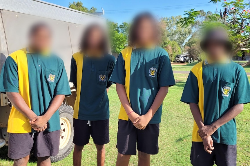 Four students in school uniform staring at camera