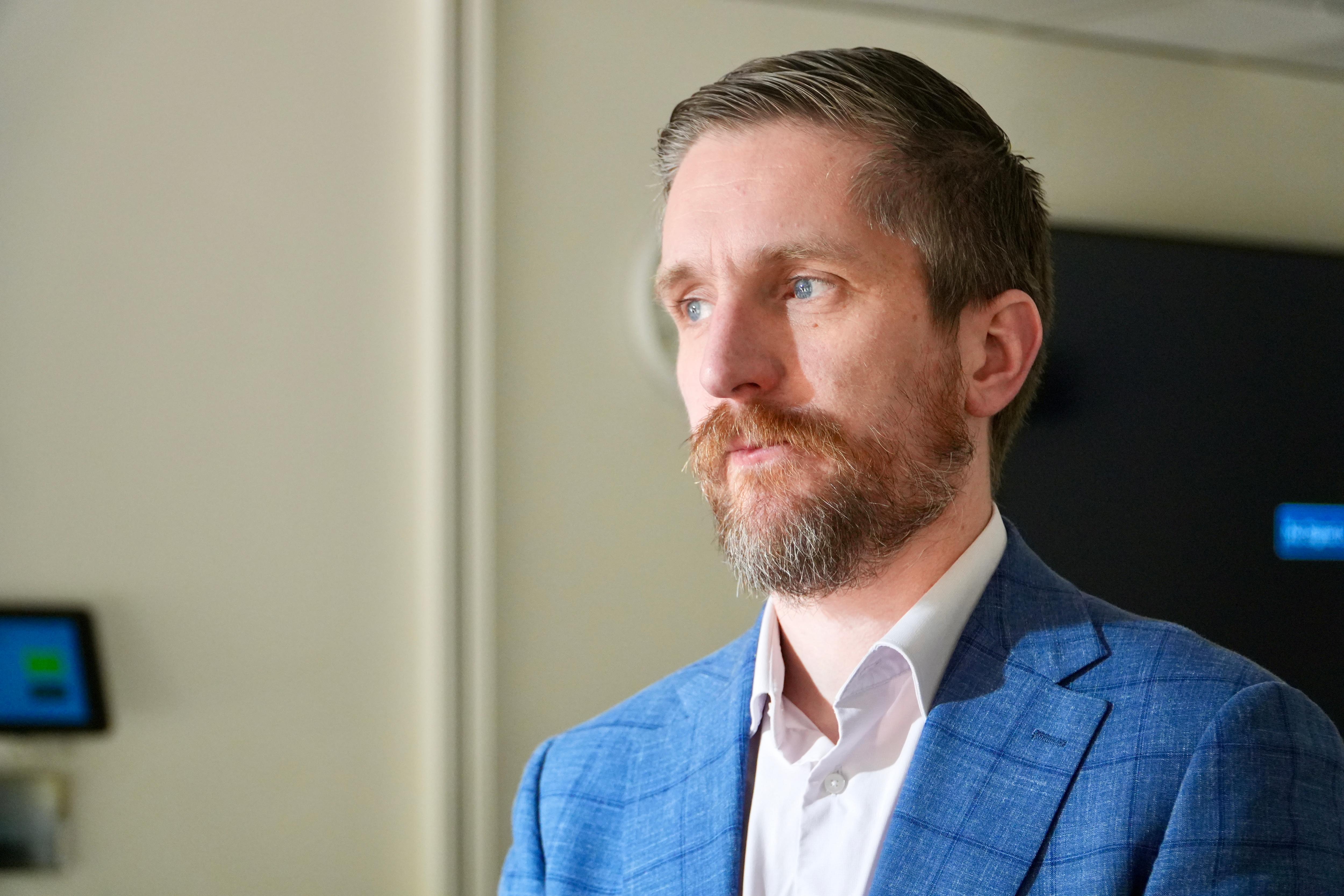 A man wearing a jacket and tie looks serious. 