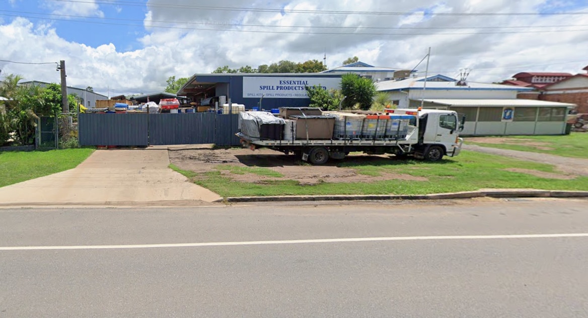 Roadway, grass driveway, high fence, loaded truck, signage, stored gear
