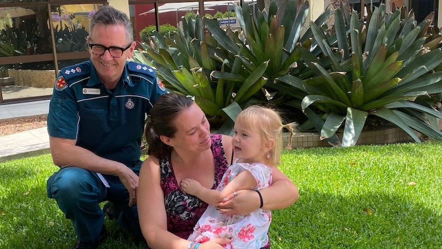 Queensland Ambulance Service Clinical Director Tony Hucker with mum Hope Summers and 2-year-old Saphira Harwood.