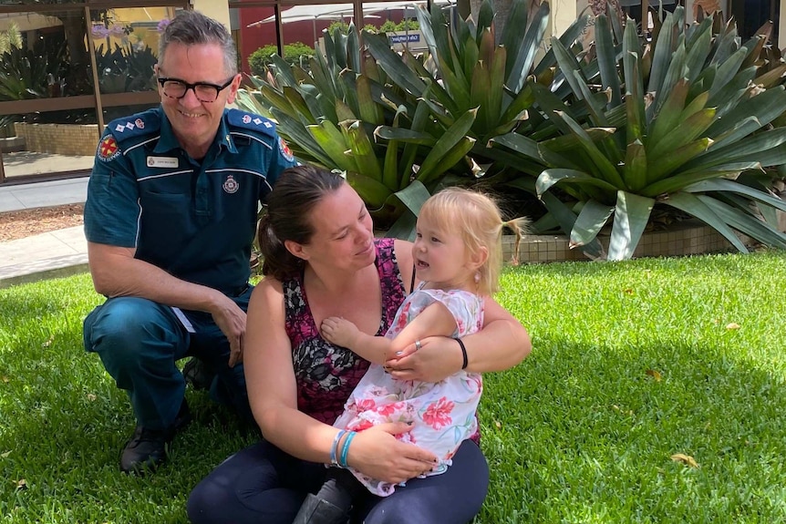 Queensland Ambulance Service Clinical Director Tony Hucker with mum Hope Summers and 2-year-old Saphira Harwood.