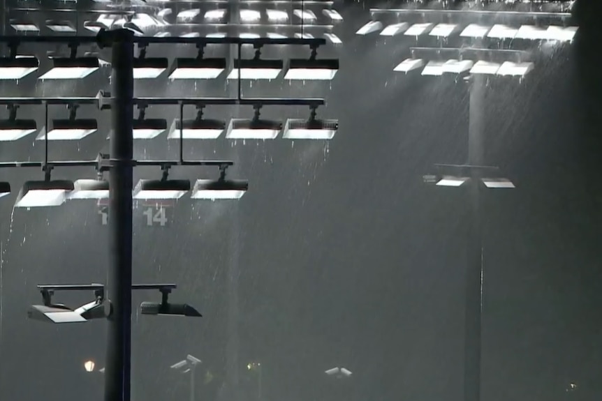 Rain drips off the lights at the US Open tennis complex