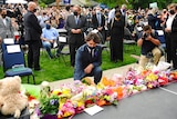 Canadian Prime Minister is pictured kneeling as he lays down flowers outside at a vigil outside of the London Muslim Mosque. 