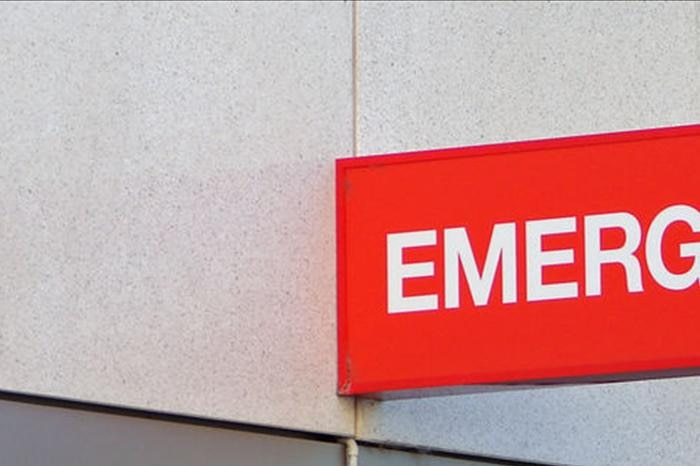 A close-up of a red emergency care centre sign.