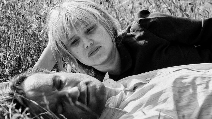 Black and white still of Joanna Kulig and Tomasz Kot laying on grass in 2018 film Cold War.