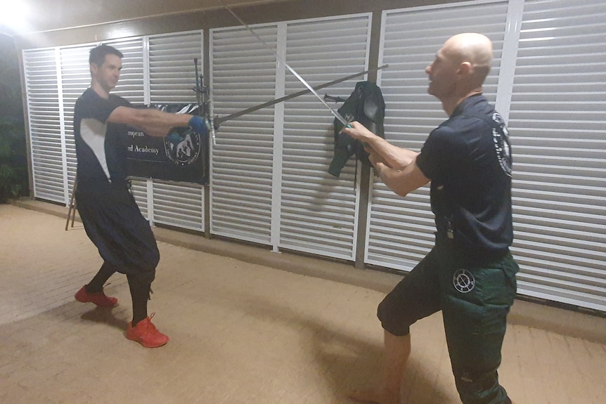 Two men sparring with swords
