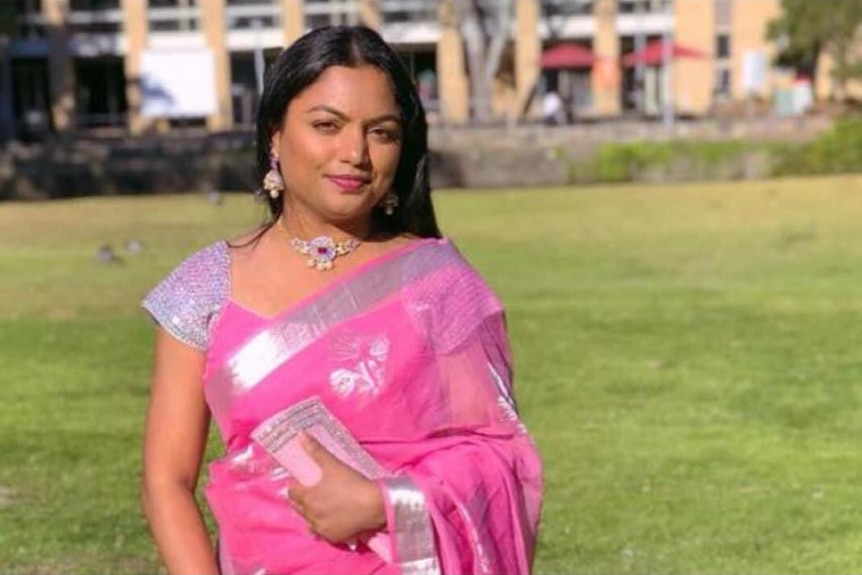 A woman in traditional Indian clothes looks at the camera