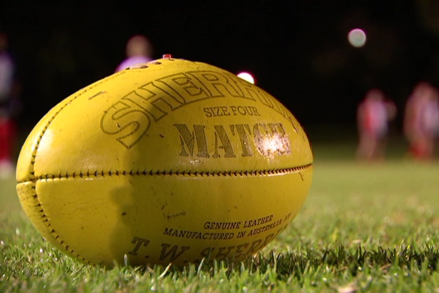 A yellow football on the ground at night