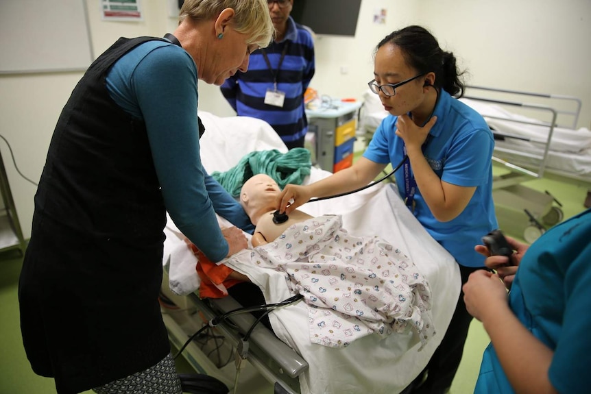 Medical students work with baby dummy