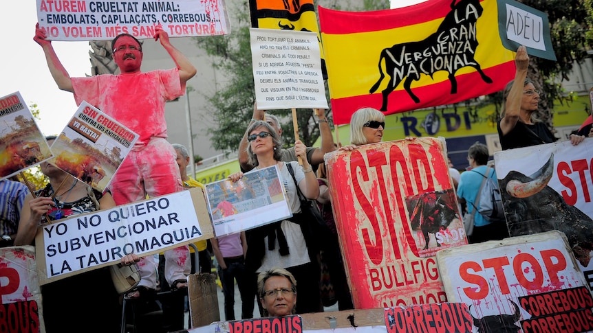 People hold up signs during a protest against bullfighting and celebrating the last "corrida" to take place in Barcelona