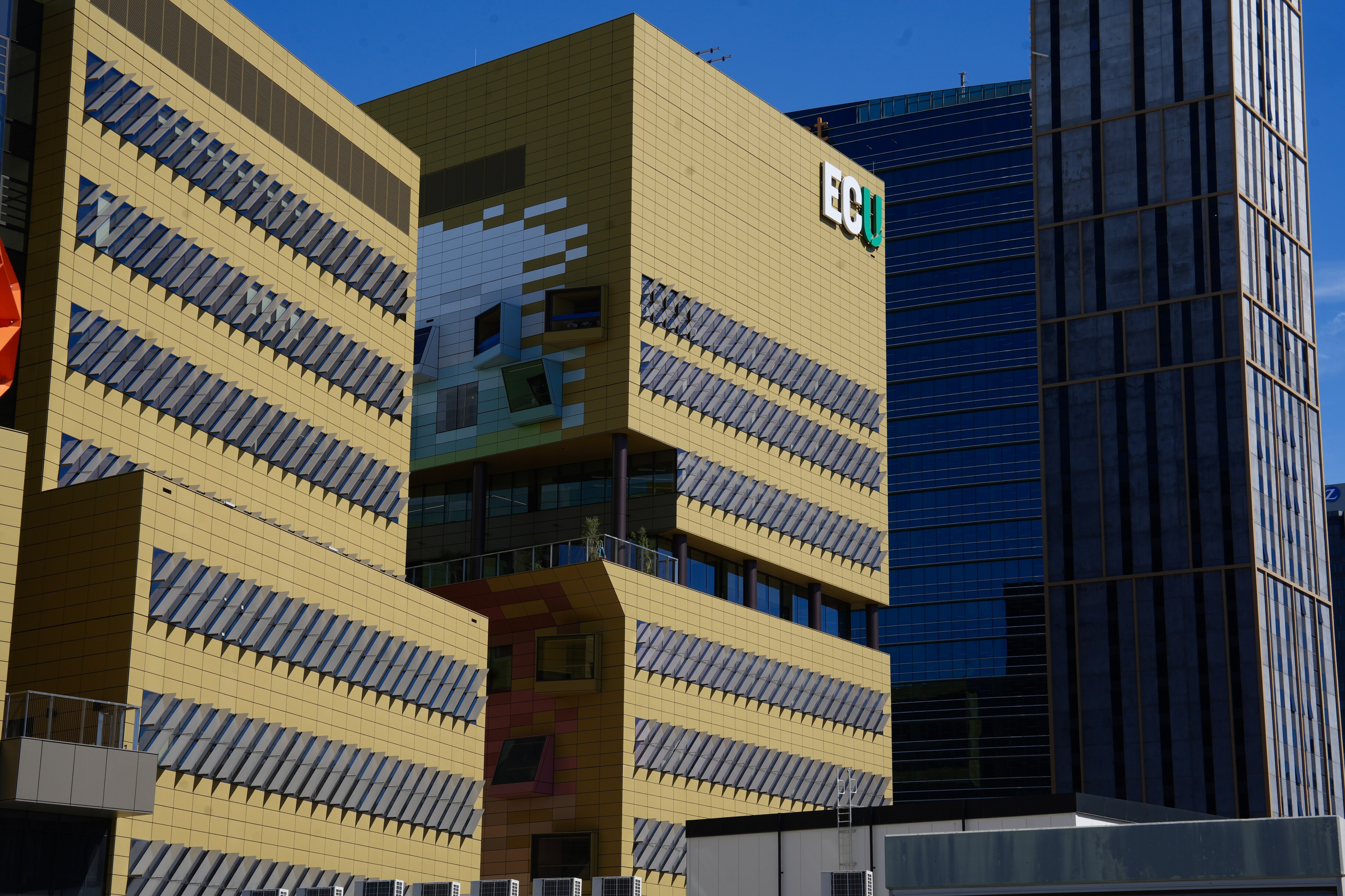 Edificios altos en el CBD de Perth bajo el sol, rematados con las letras ECU