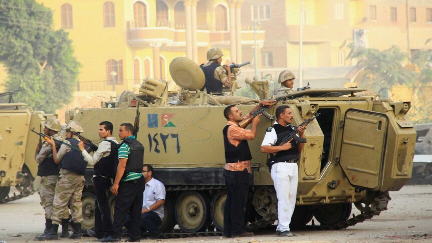 Security forces aim their weapons as they stand guard during clashes with gunmen in Kerdasa in Egypt.
