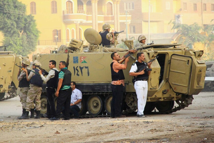 Security forces aim their weapons as they stand guard during clashes with gunmen in Kerdasa in Egypt.