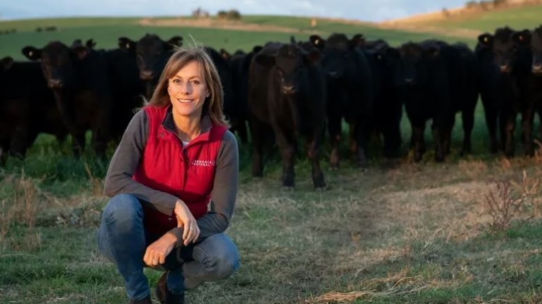 woman on farm with angus cattle in background