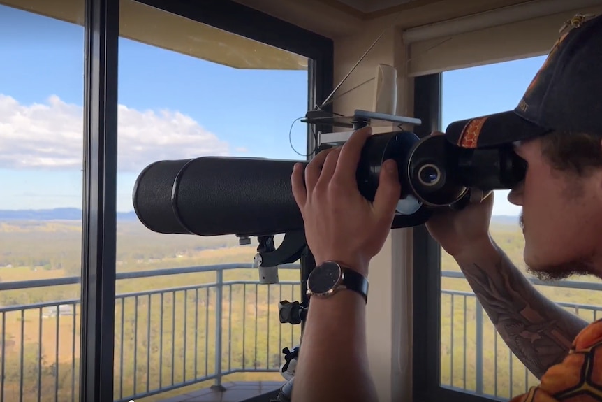 James Evans looking through binoculars at Girvan Estate