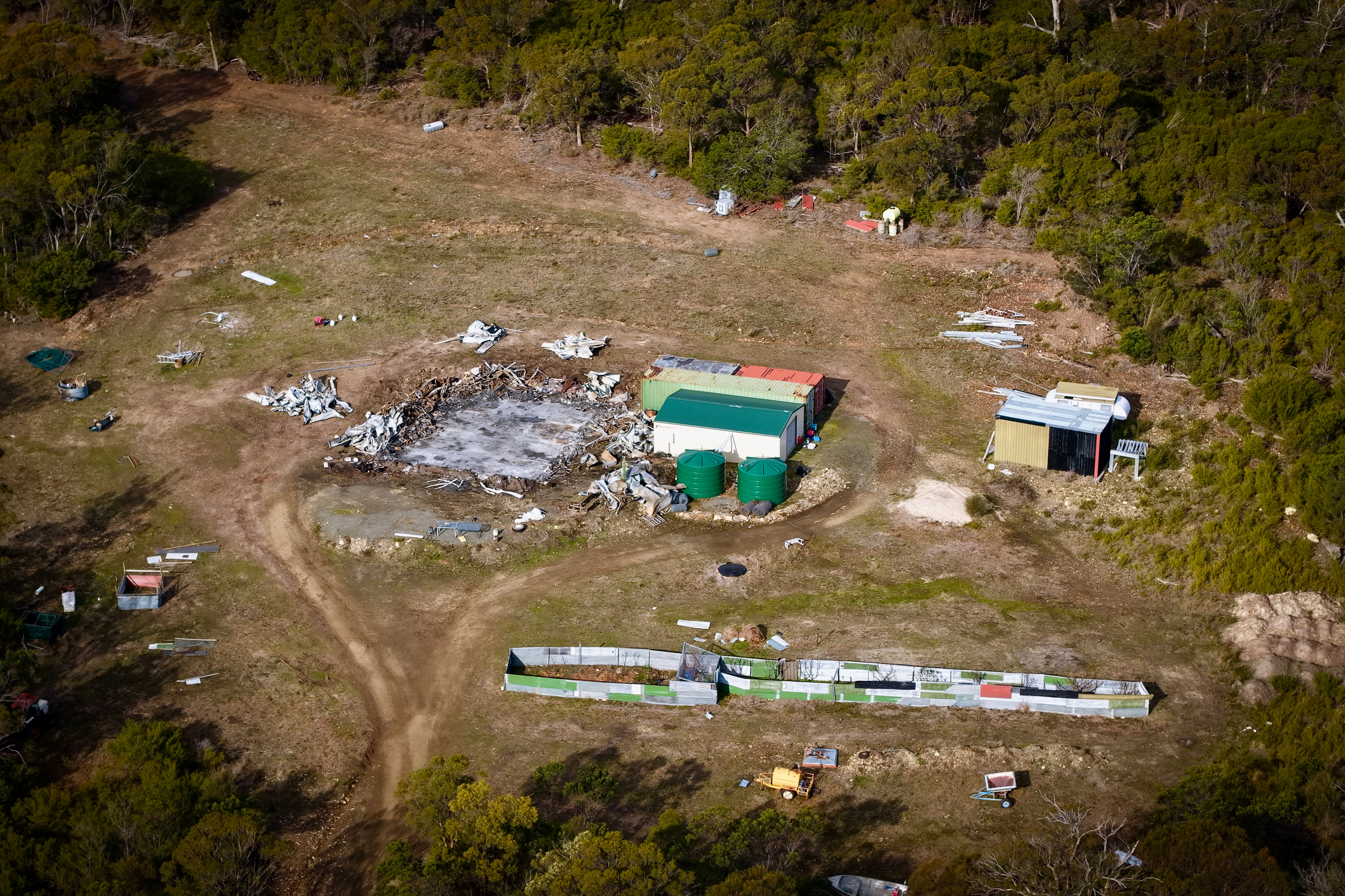 Aerial and ground views of a rural residence destroyed by fire.