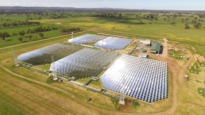 A drone photo of a solar plant with tall towers on each end.