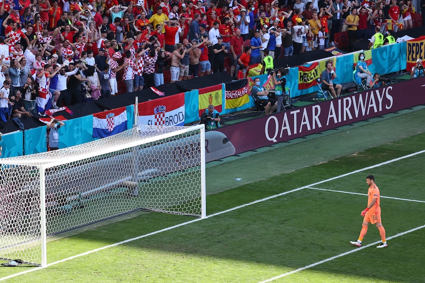 Unai Simon vuelve a su meta mientras los aficionados croatas celebran