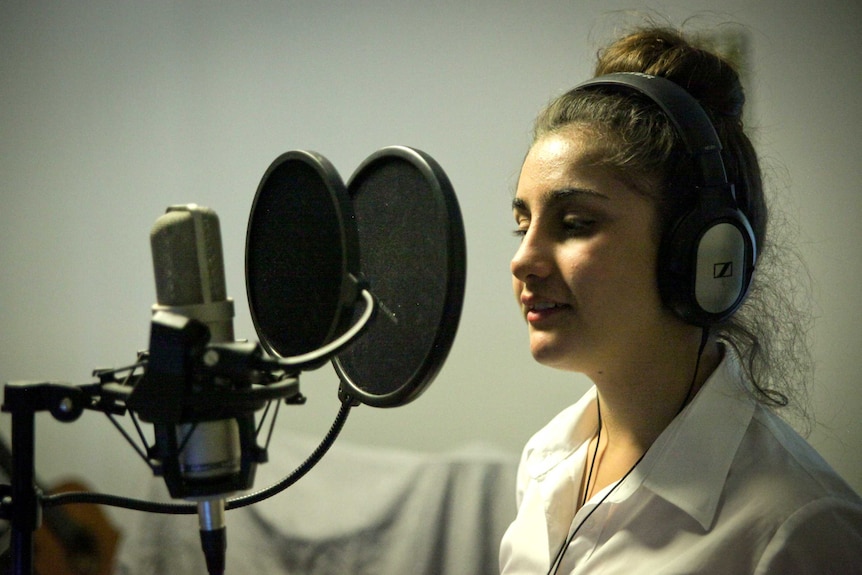 Aranmore Catholic College student Rita Yousif in front of a microphone during a musical recording session.