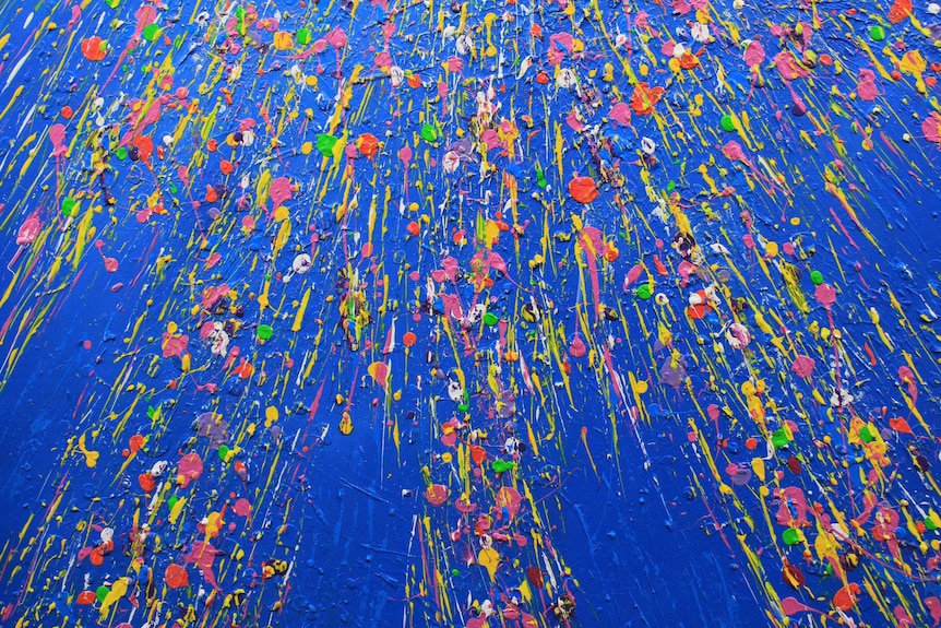 Detail image of a colourful paint splattered canvas