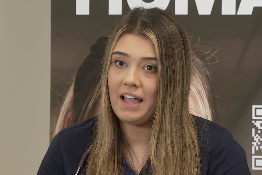 A young woman talks to the media