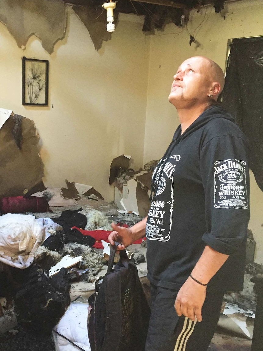 A man surveys is fire-damaged unit.