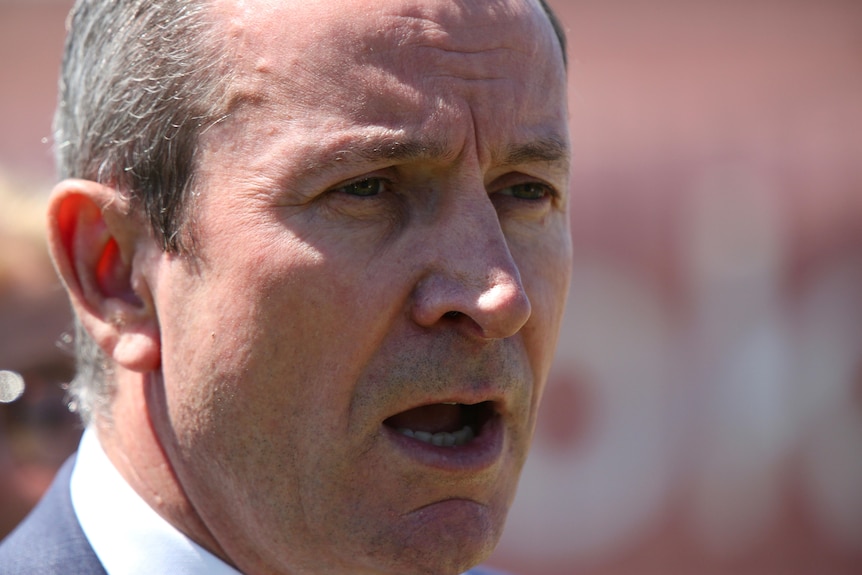 A close-up shot of WA Premier Mark McGowan's face as he speaks to reporters outdoors.