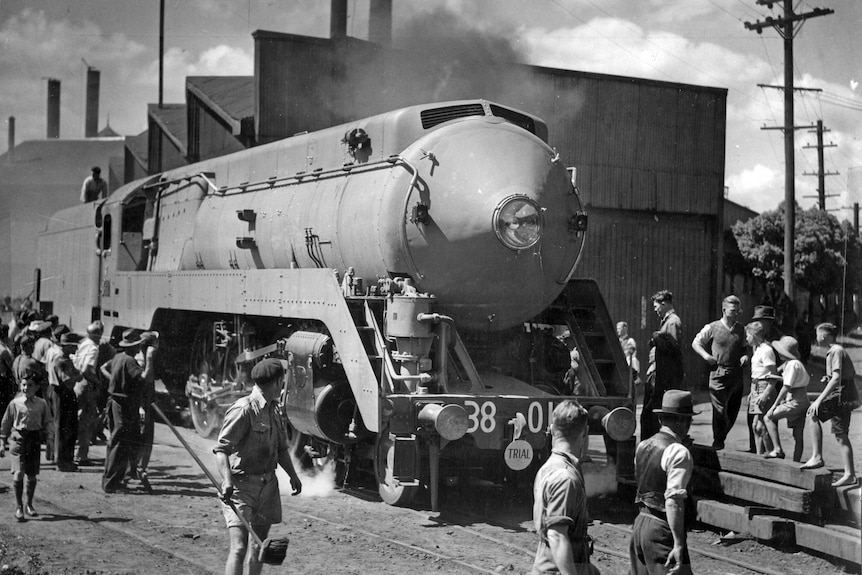 Black and white photo of train, people surround it