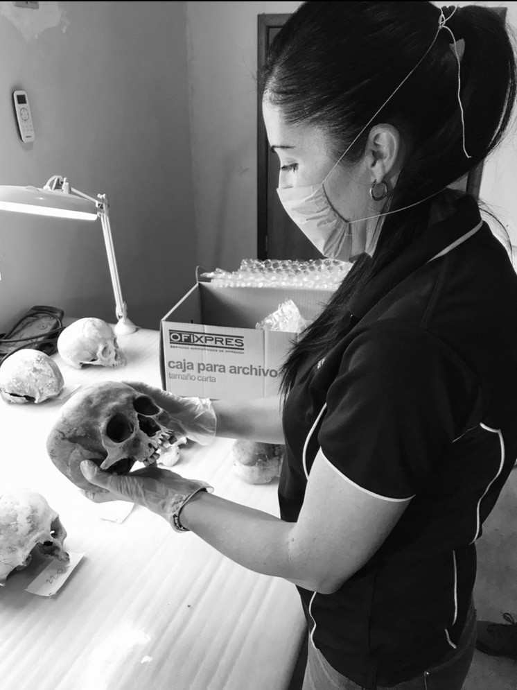 Young woman holds an ancient skeleton in her hands